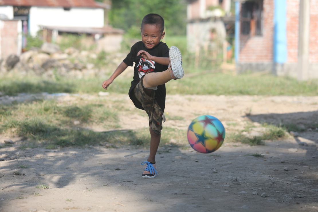 A little boy fitted with prosthesis is playing football Humanity & Inclusion Nepal Projects