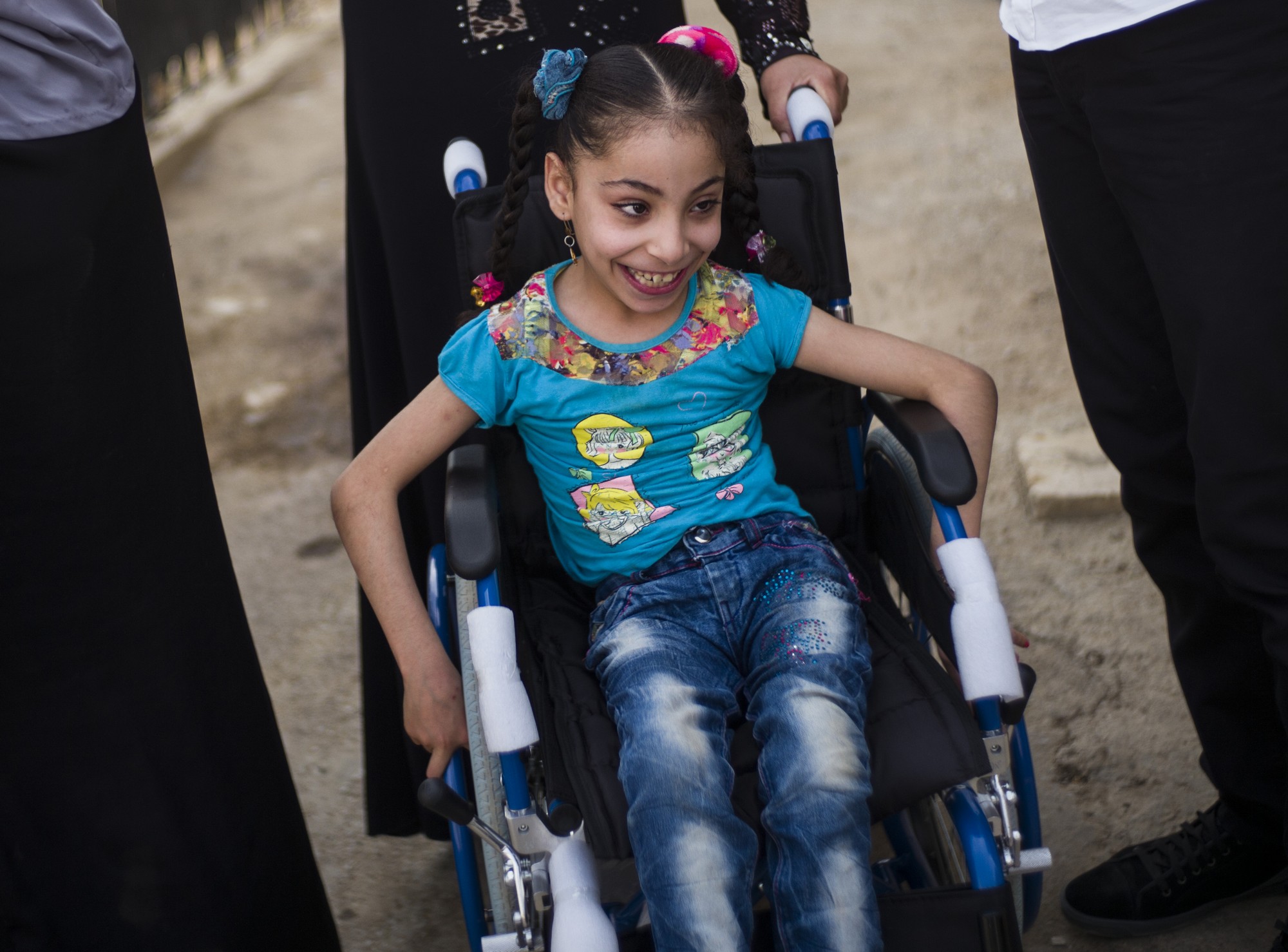 Dalal, 7 ans, peut désormais sortir à nouveau de chez elle grâce au fauteuil roulant de Handicap International. © C. Fohlen / Handicap International