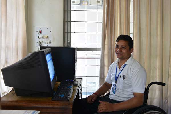 A wheelchair user working in the reception at the NNSWA rehabilitation centre.