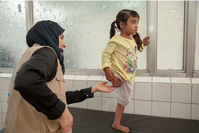 A young girl amputee taking part in a rehabilitation session.