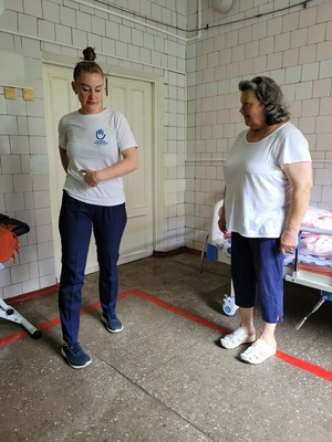 Physical therapist Anastasia (left) demonstrates exercises for Nadezhda (right). © HI