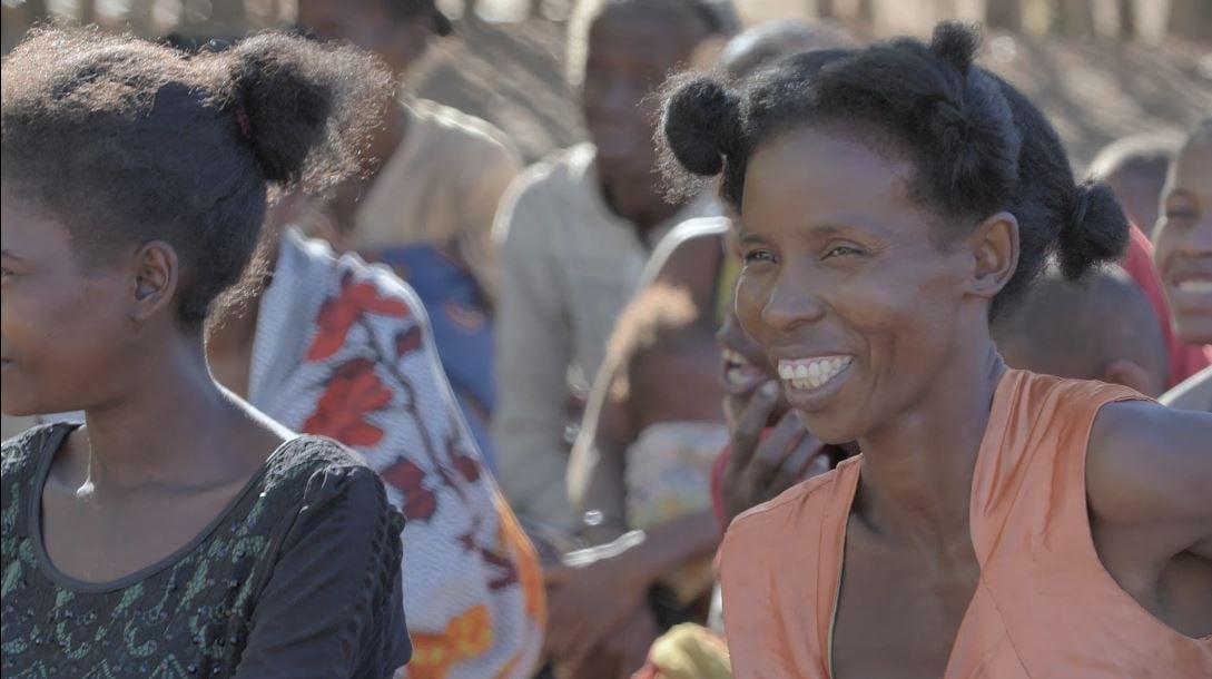 Liva smiles and listens to an information session about reproductive health. 