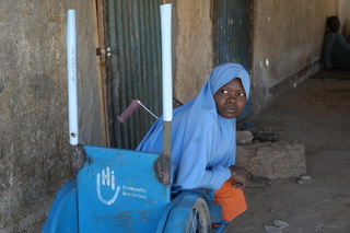 Roumanatou in the tricycle given to her by HI. © J. Labeur / HI