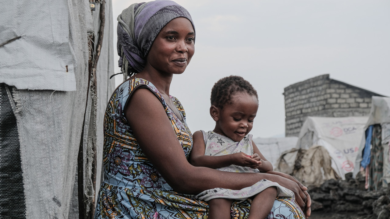 Close-up portrait of a woman holding a little girl on her lap.