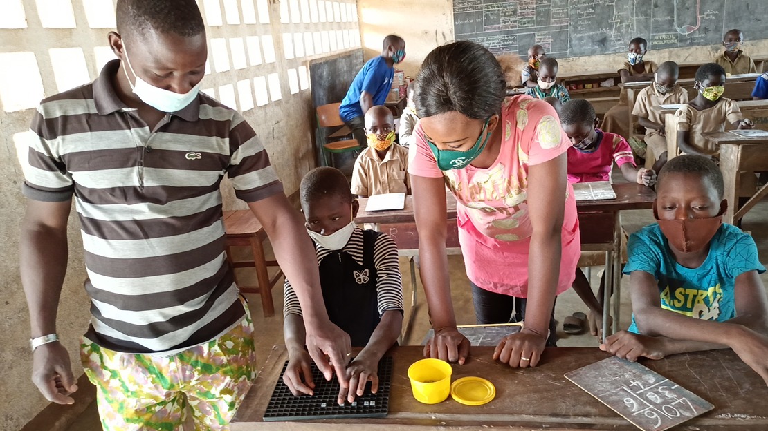 Yentougle being supported by the itinerant teacher (right) and the class teacher (left).