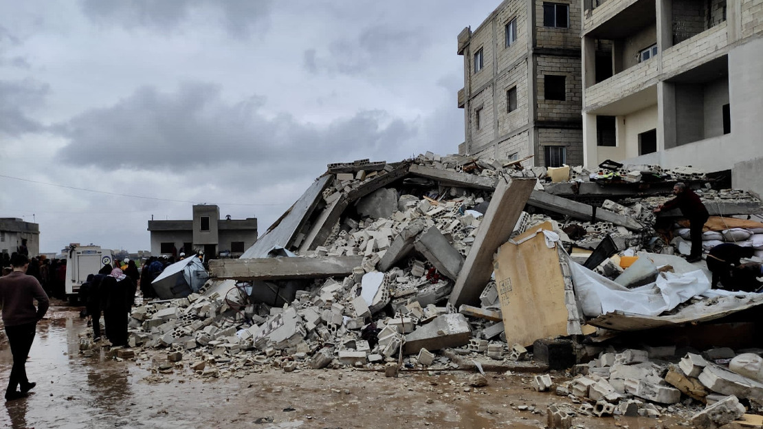 People in front of a collapsed building
