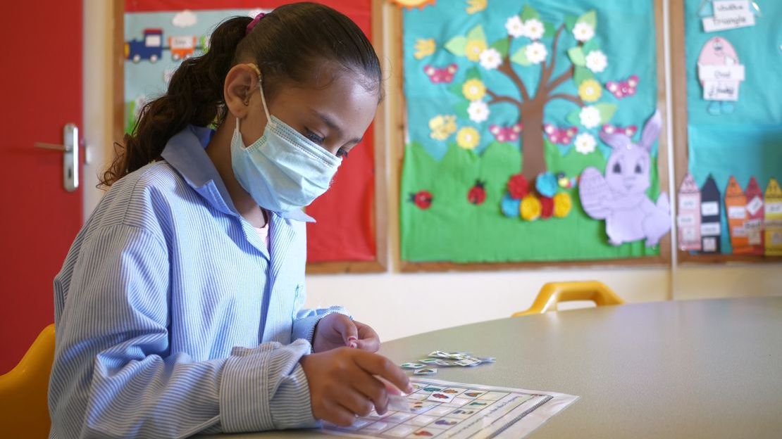 Imane, in her classroom, using a visual aid to carry out an activity.