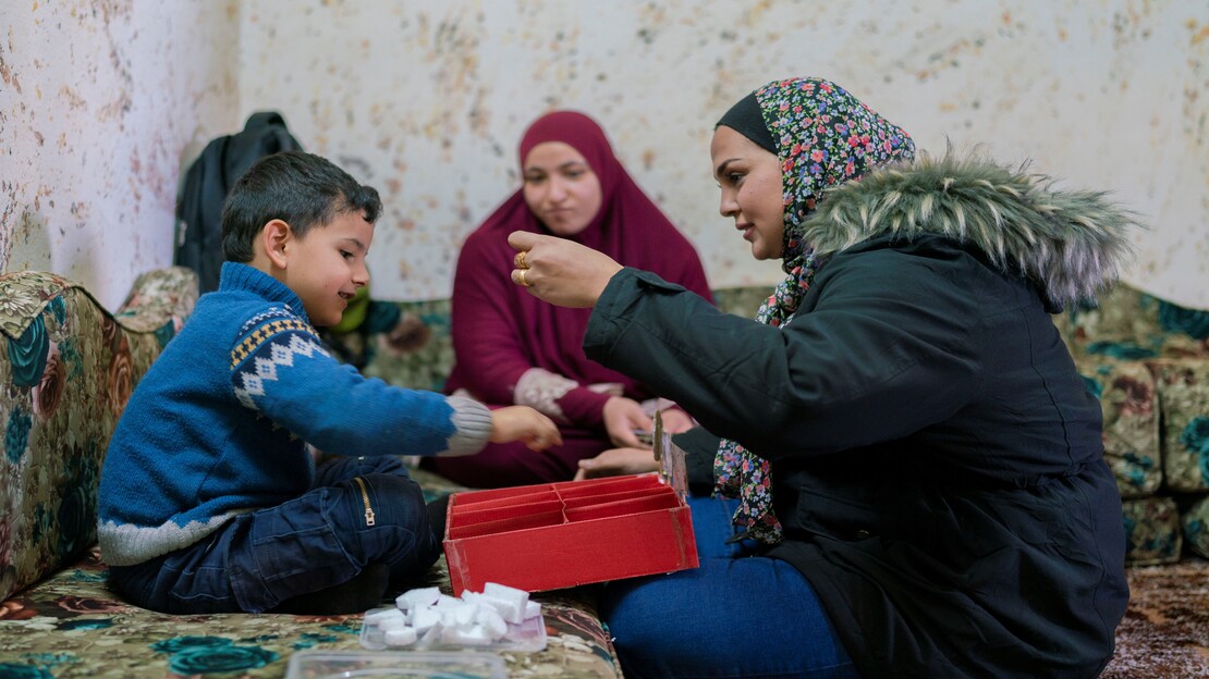 Khaled is doing concentration exercises with his mother Esra and HI staff