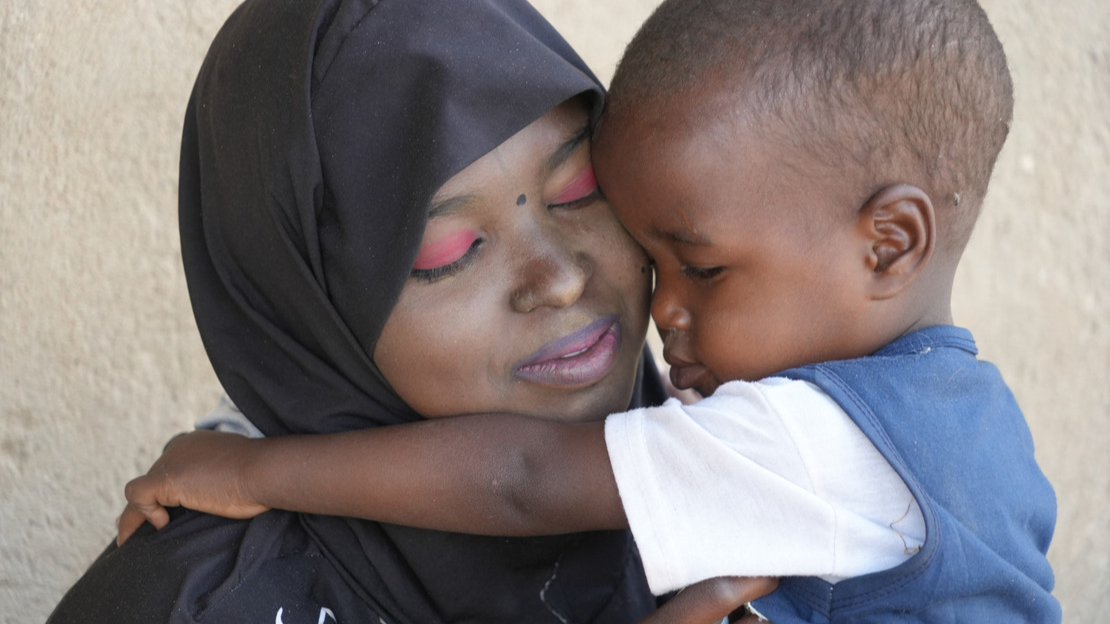 Close-up shot of Mohamed and Azima hugging.