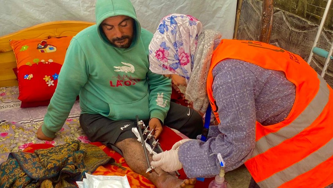 Wala cleaning the injury of a patient in a shelter in Rafah. 