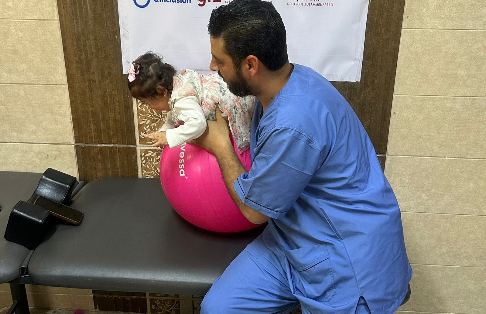 Aesha during a rehabilitation session with HI specialist to strenghten her back