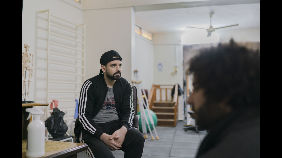 Omar sitting on a chair at the HI centre in Jordan