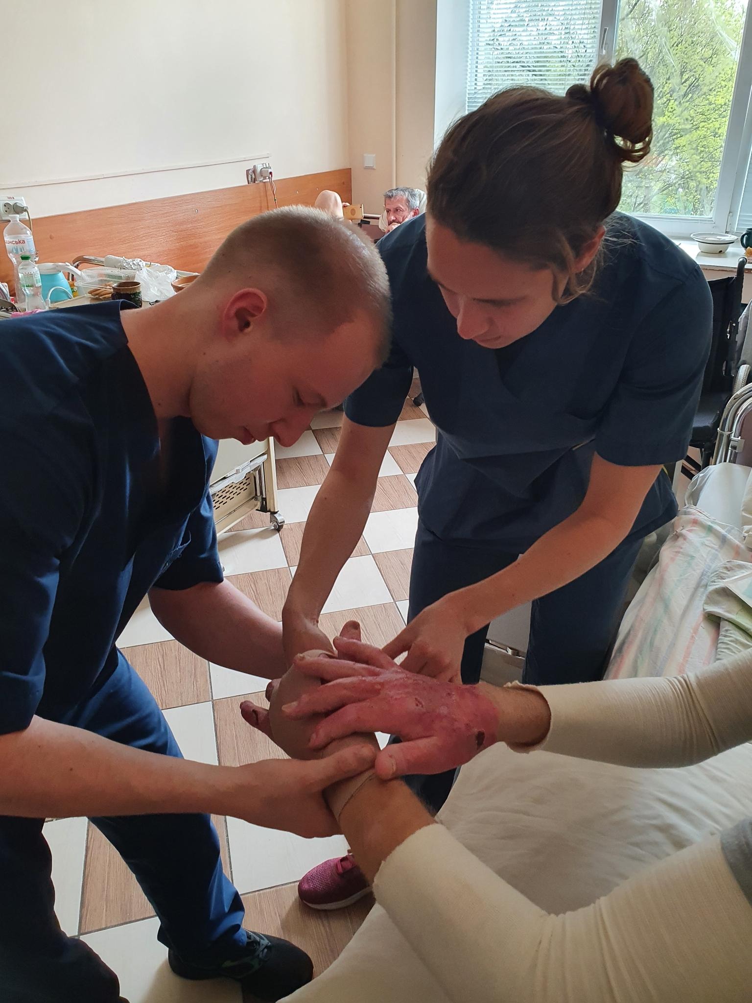 Violette provides practical on-the-job training to Ivan, a physical therapy student in Ukraine