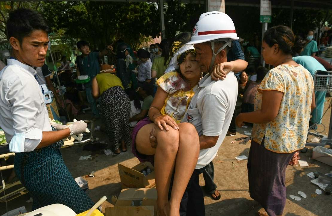 An earthquake survivor is carried as she waits to receive medical attention at a hospital in Naypyidaw on March 28, 2025, after the earthquake in central Myanmar.