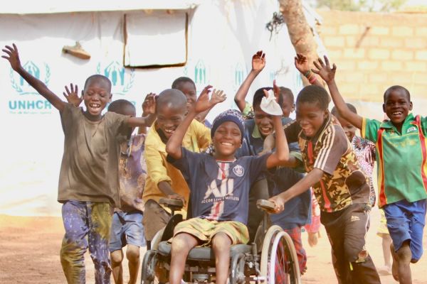 A child in a wheelchair in a group of friends in an inclusive school in Burkina Faso