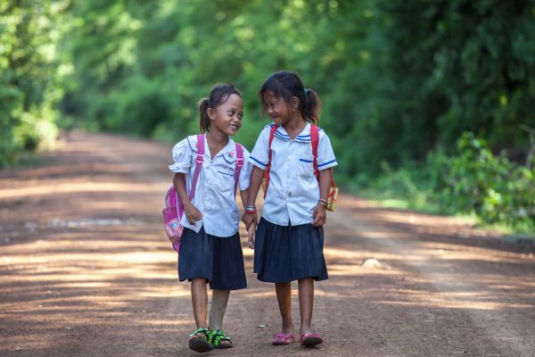 Channa, a young amputee supported by HI, on her way to school with a friend in Cambodia. 