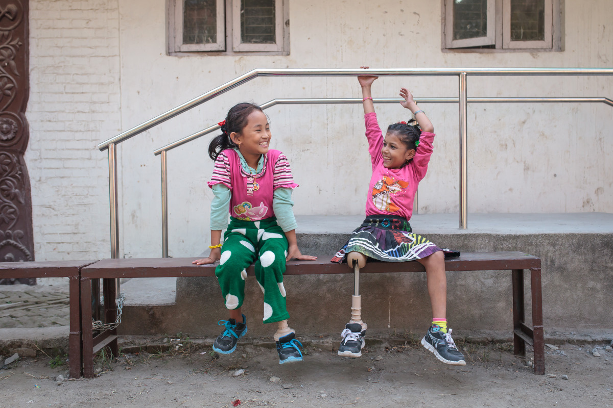 Nirmala and Khembro, two girls you lost a leg in the Nepal earthquake, sit together at HI's rehabilitation centre. They have both been fitted with prosthetic legs.