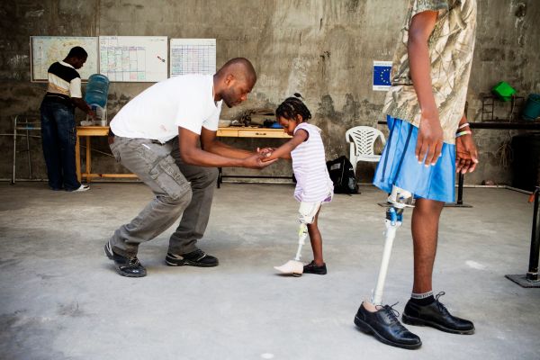 A young girl learning to walk again on her new artificial leg, Port-au-Prince, Haiti.