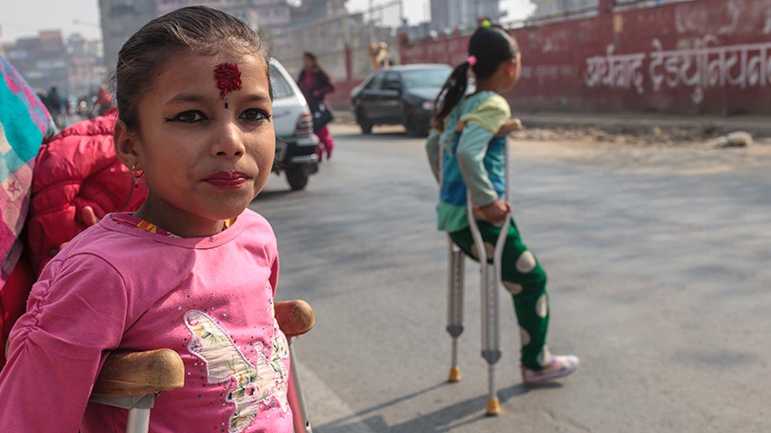 Nirmala and Khendo crossing the road on their way to a rehabilitation session, Nepal