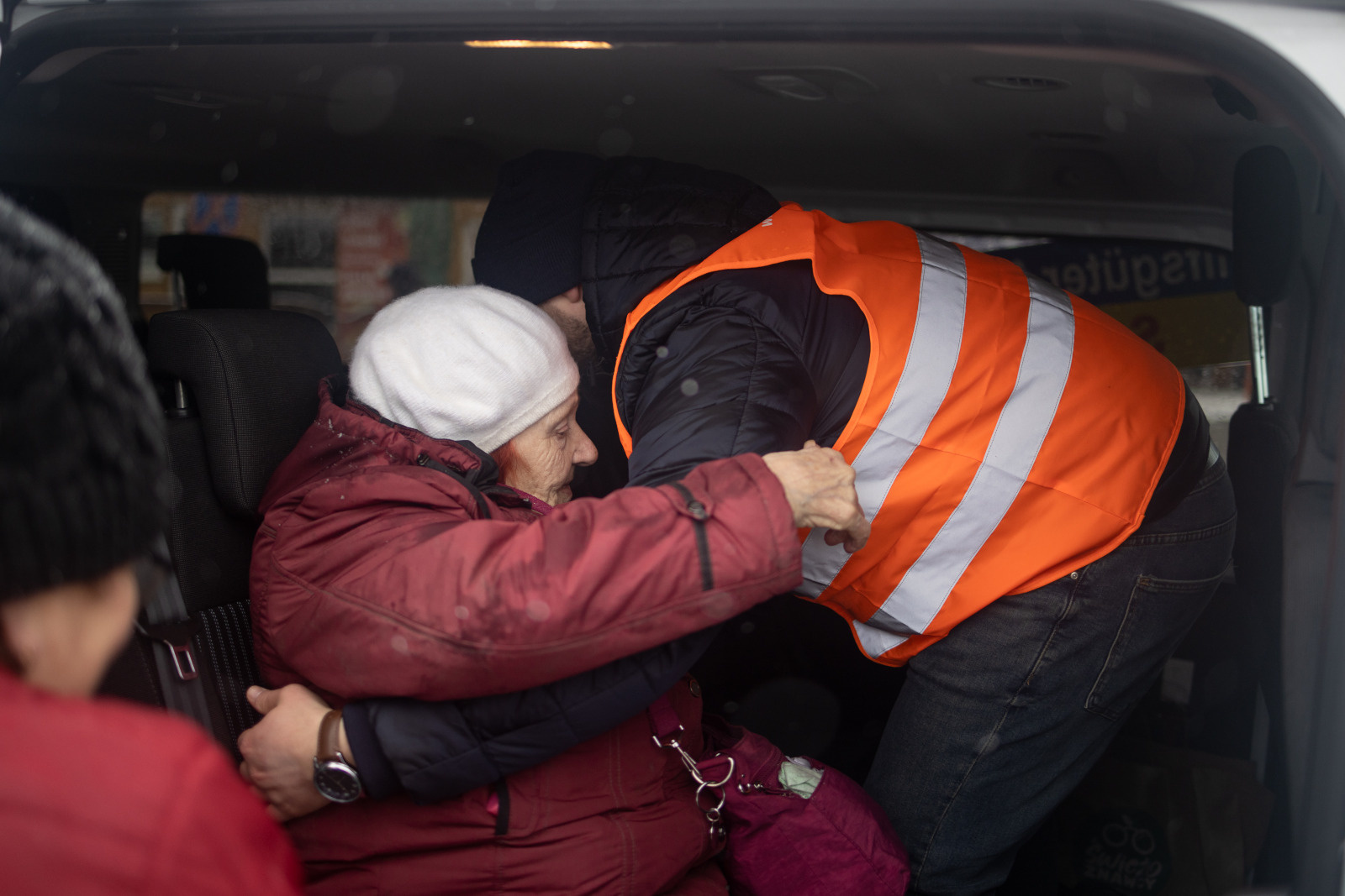 Galaina Mama Gala's son Vlad, helps her get in the car. She crossed the border from Ukraine to Poland, 2022.