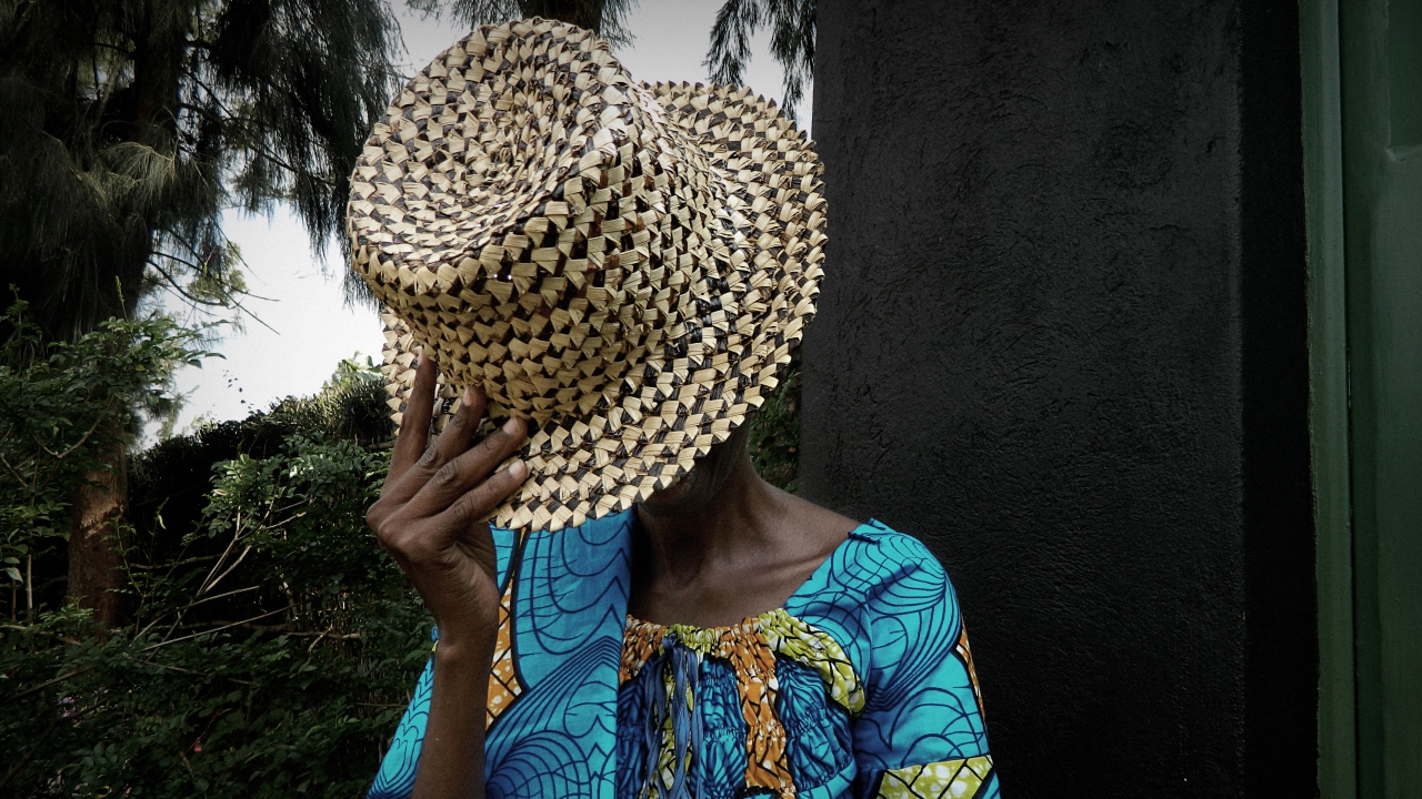 A woman with her face hidden by a hat.; }}