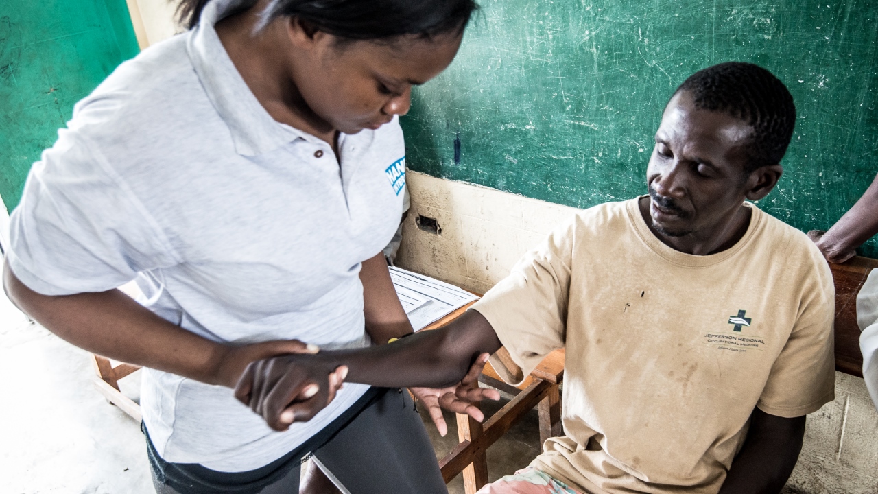 A man with hemiplegia receiving rehabilitation care from a Handicap International physiotherapist, Haiti.; }}