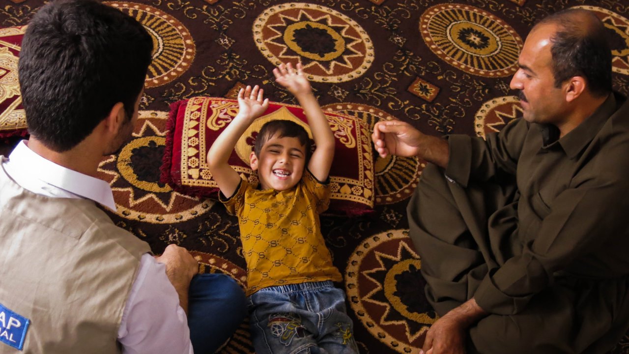 Razgar shows Hardi the exercises he does with his son every day.; }}