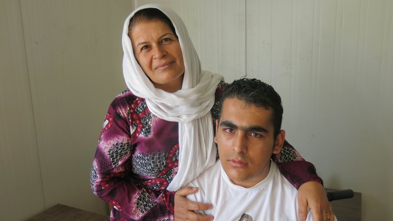 Badria and her son at a meeting organised as part of a capacity-building project for Syrians with disabilities and injuries. ; }}