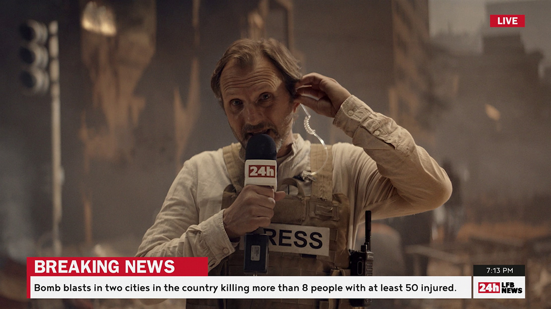 A journalist reporting on a scene of a bomb blast