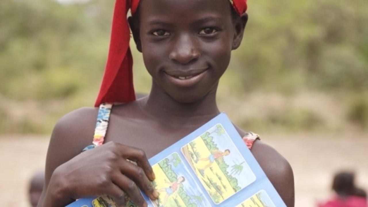 Having just attended an awareness raising session, 11-year-old, Awo Goudiaby holds up a leaflet with drawings depicted important safety messages. Senegal.; }}