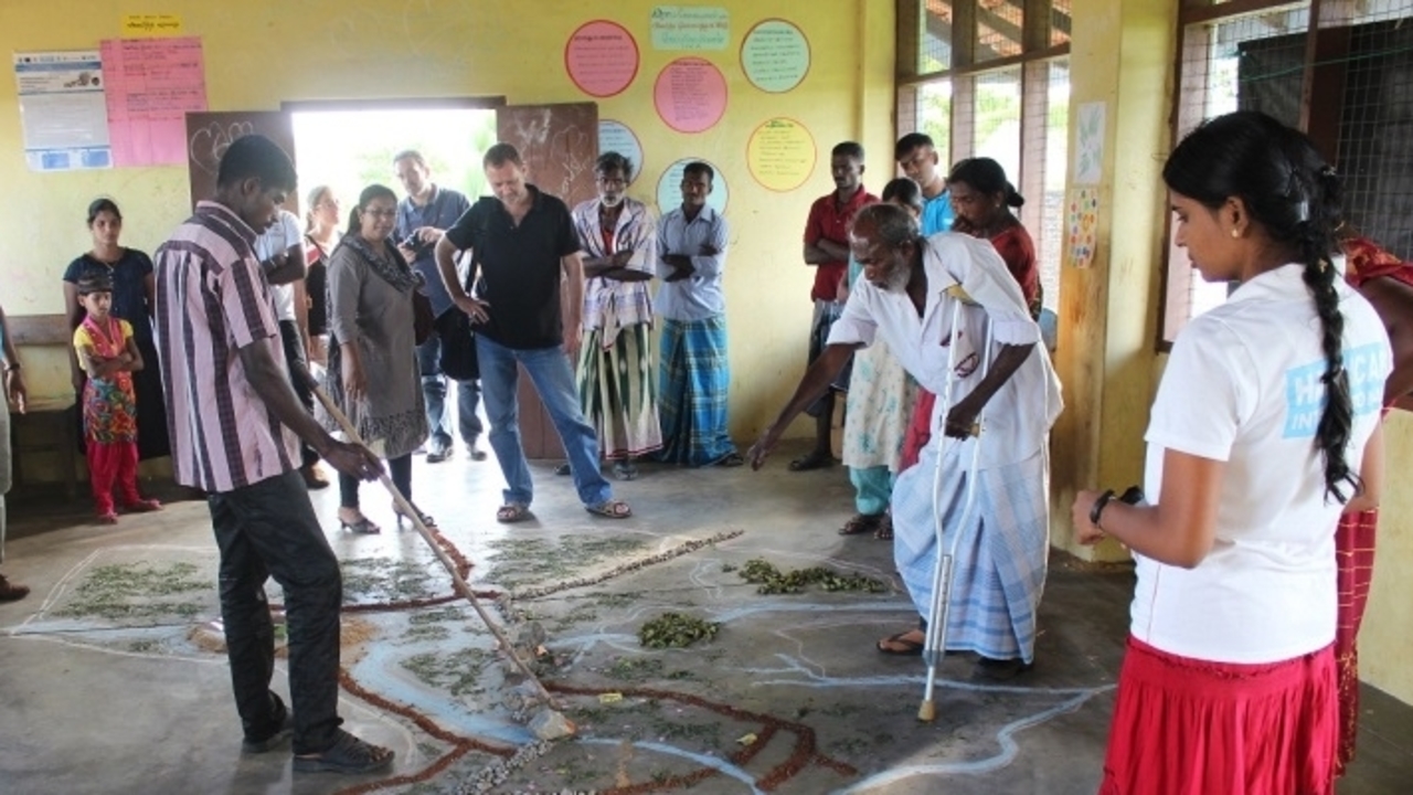 Villages in the Batticaloa region of Sri Lanka meet to draw up an emergency evacuation plan. They have drawn a map of the village on the ground. ; }}