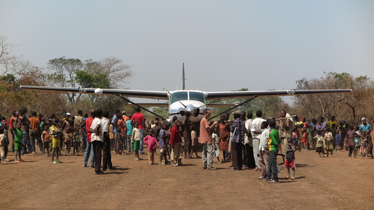 Inhabitants of Sibut greet the first aeroplane to land on the airstrip since its rehabilitation.; }}