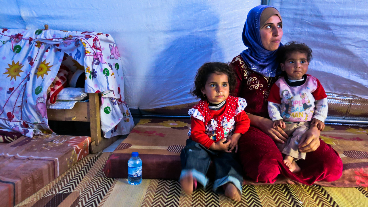 Hana and her three children in their tent.; }}