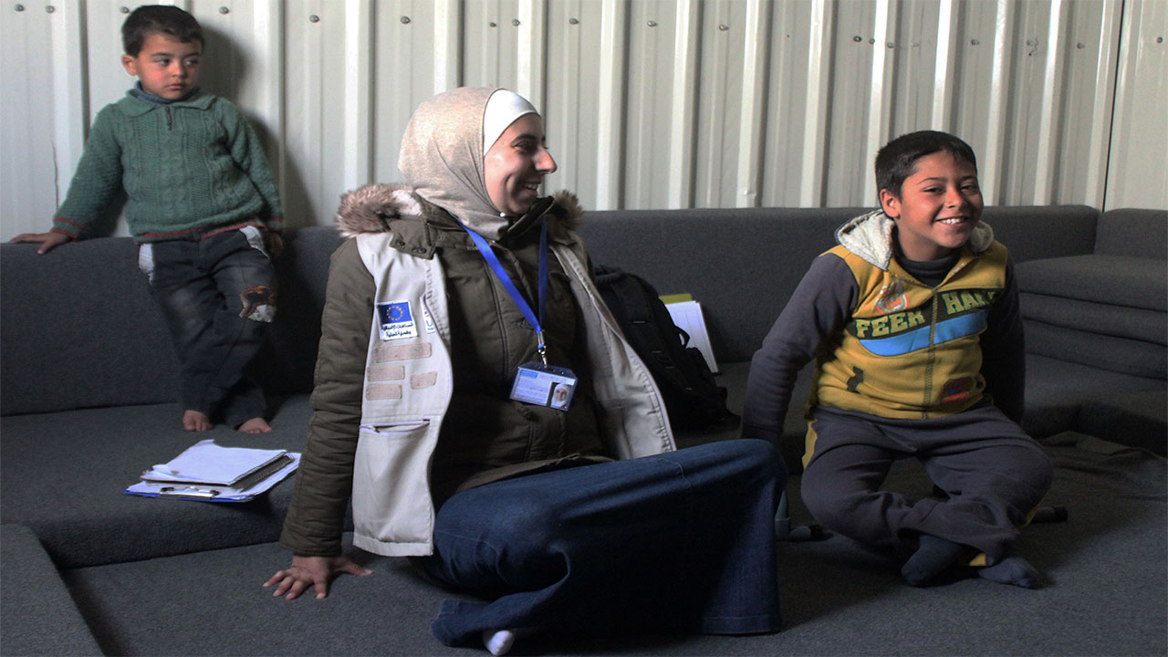 Ahmad and physiotherapist Noor during a rehabilitation session in Azraq refugee camp. Jordan.; }}