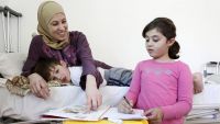 Haya, a disabled SYrian refugee, with her two children.