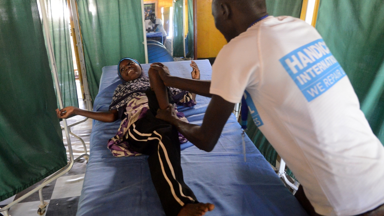 Halima, 9, in a rehabilitation session with a Handicap International physiotherapist.; }}