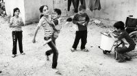 Aya is carried by her sister Iman in a game of hopscotch; }}