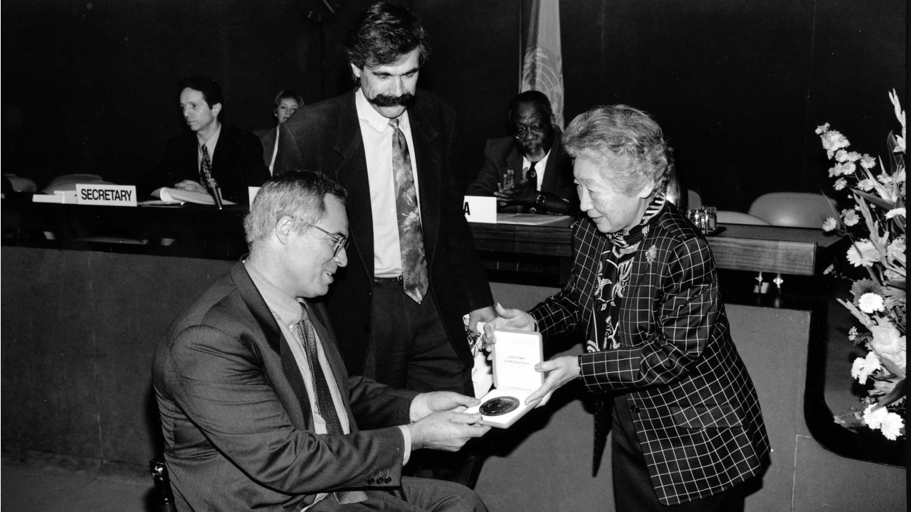 The United Nations High Commissioner for Refugees, Mrs Sadako Ogata, presents the Nansen Medal Award to Dr Jean-Baptiste Richardier, founder of Handicap International, and Patrick Segal, the organisation’s then vice-chairman.; }}