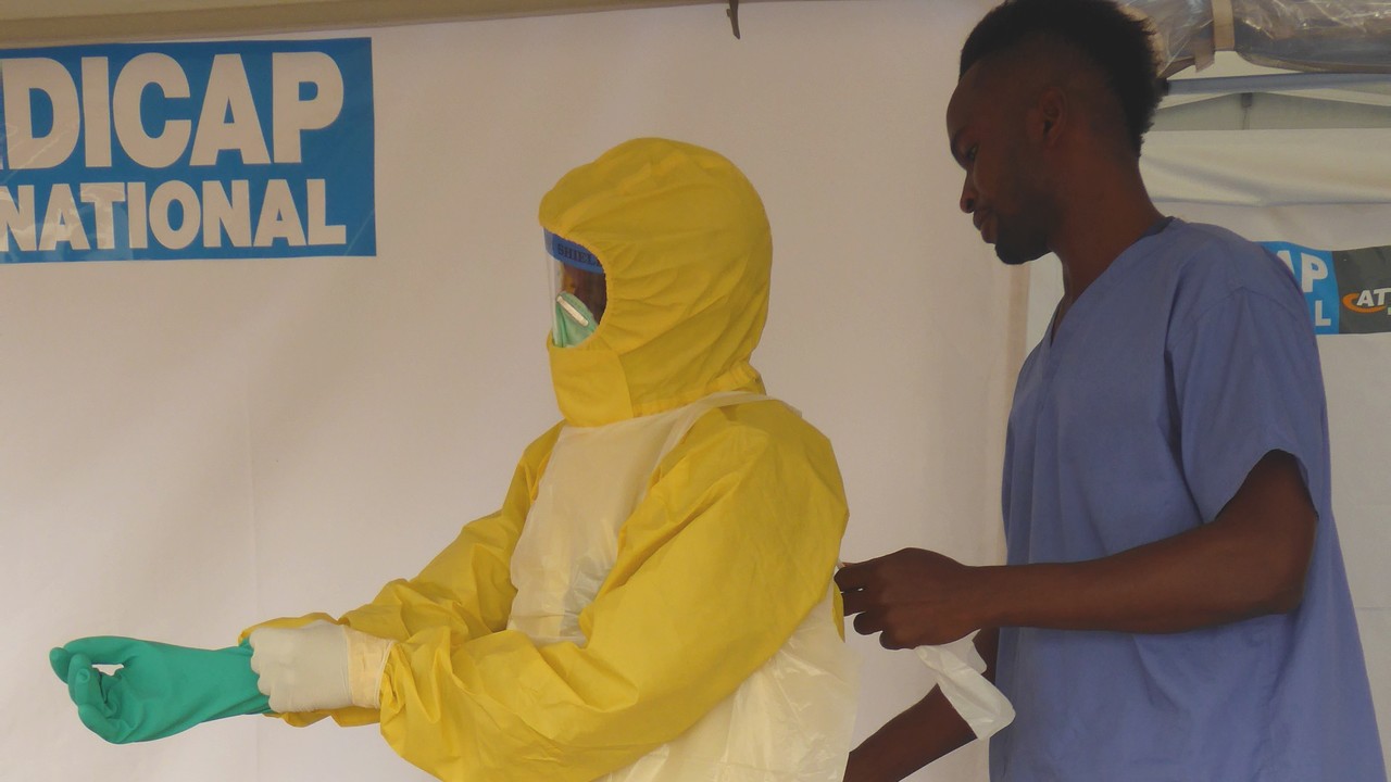 Members of Handicap International's ambulance service team cleans an ambulance with a chlorine solution. Sierra Leone.; }}