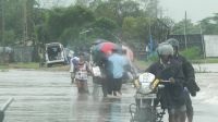 People wade through floods waters on the road from Veechikalmunai to Batticaloa. Sri Lanka.; }}