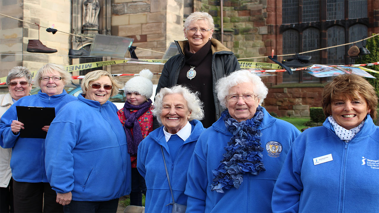 Tamworth Soroptimists outside St. Editha’s Church where they built a Pyramid of Shoes on a windy Friday morning.; }}