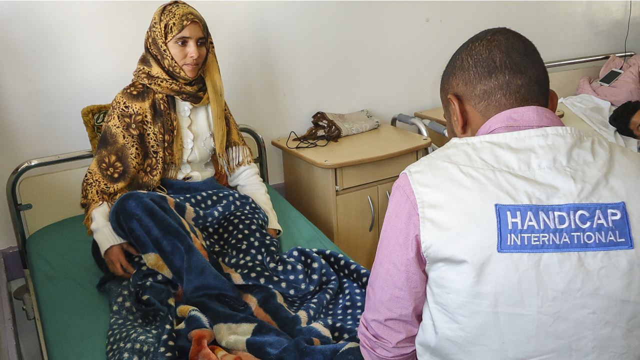 Saeed, a Handicap International physiotherapist, with a patient at the Al-Thawra hospital in Sanaa, one of the main hospitals providing care for victims of the conflict. ; }}