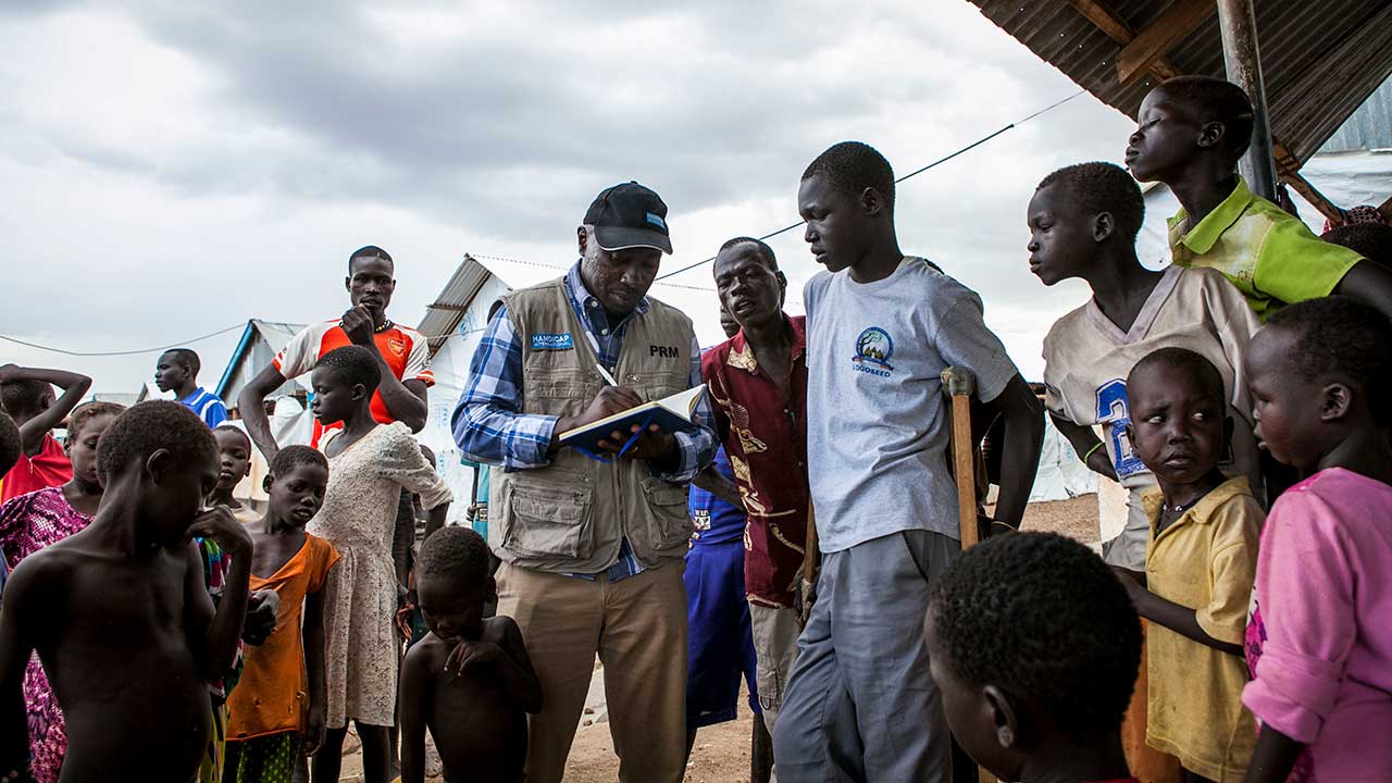 Handicap International rehabilitation team leader Kibet speaks with Simon Ochiti at Kakuma reception centre.